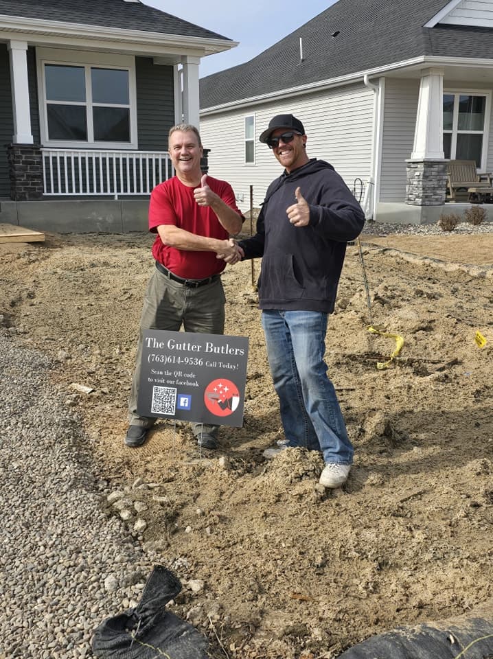 Derek shaking hands with a customer in front of a newly built home