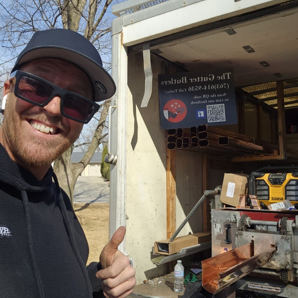 Derek and the fabrication trailer with copper-toned seamless gutters
